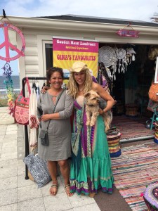 Carin geposeerd met Gina en haar hondje Happy. Op de achtergrond Gina’s winkeltje