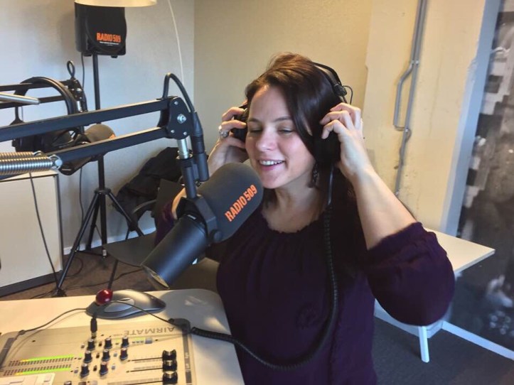 Annemiek in een radio uitzending, zittend met koptelefoon op haar hoofd